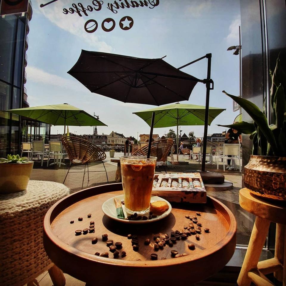 Glas met koffie op een tafeltje achter het raam bij Barista café alkmaar