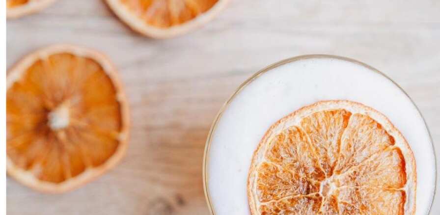 bovenaanzicht met een cocktail met een sinaasappelschijf erin