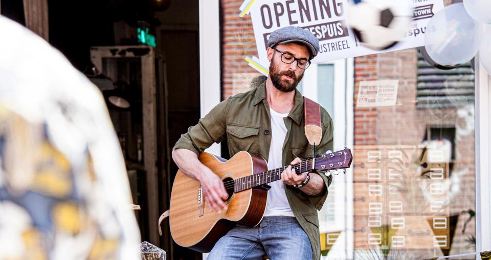 Guy rooks met een houten gitaar