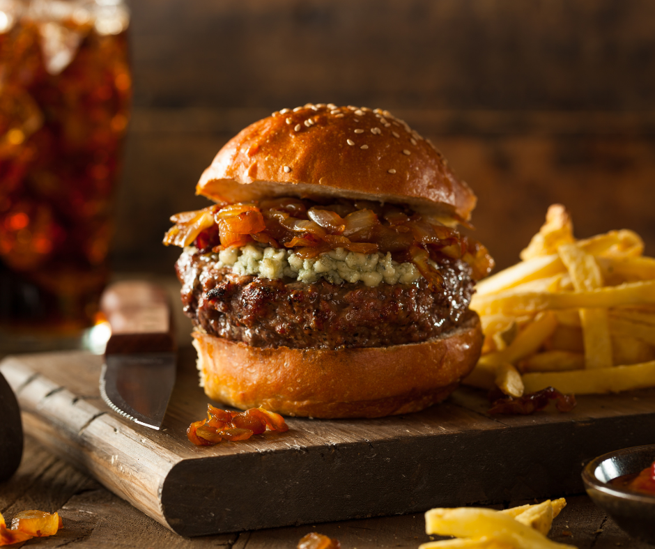 Stockfoto van een hamburger op een houtenplank met patat ernaast