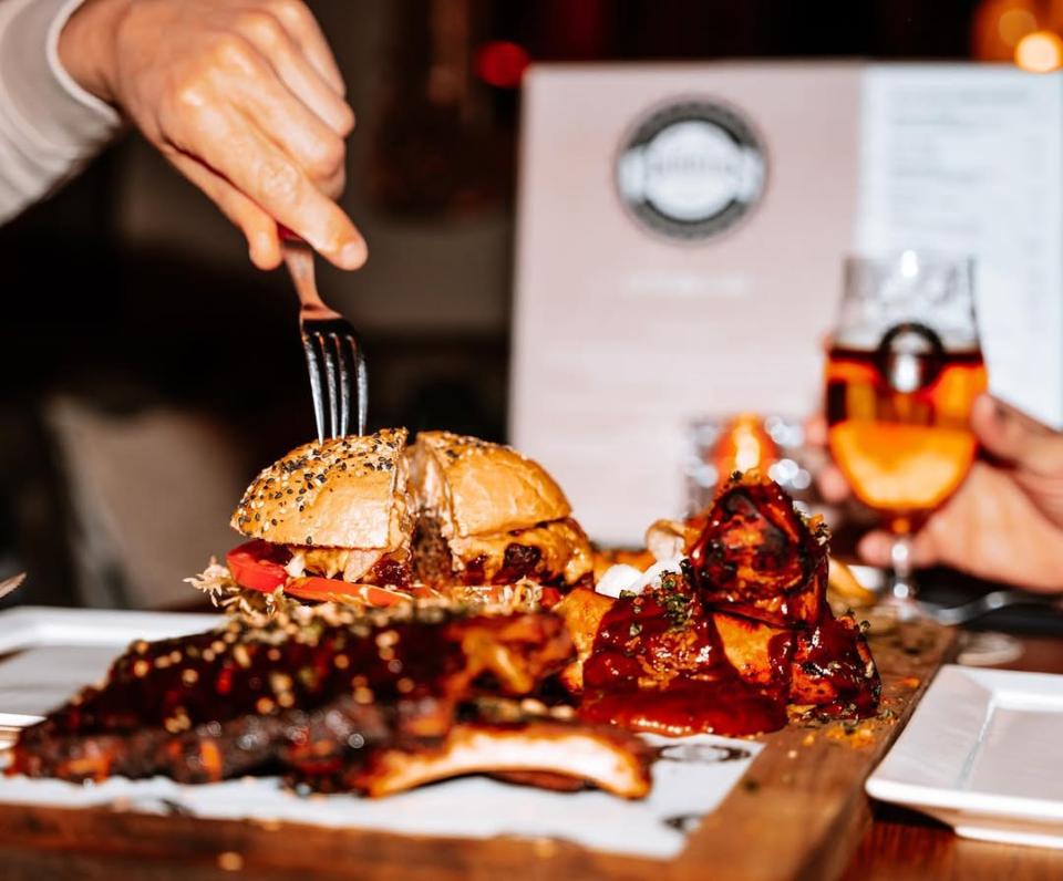 Vork in een hamburger met op de voorgrond spareribs