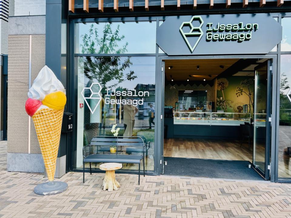 Vooraanzicht ijssalon de wacht met een groot beeld van een ijsje