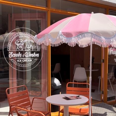 buitenaanzicht van scoobs en winstons met een roze parasol voor het raam