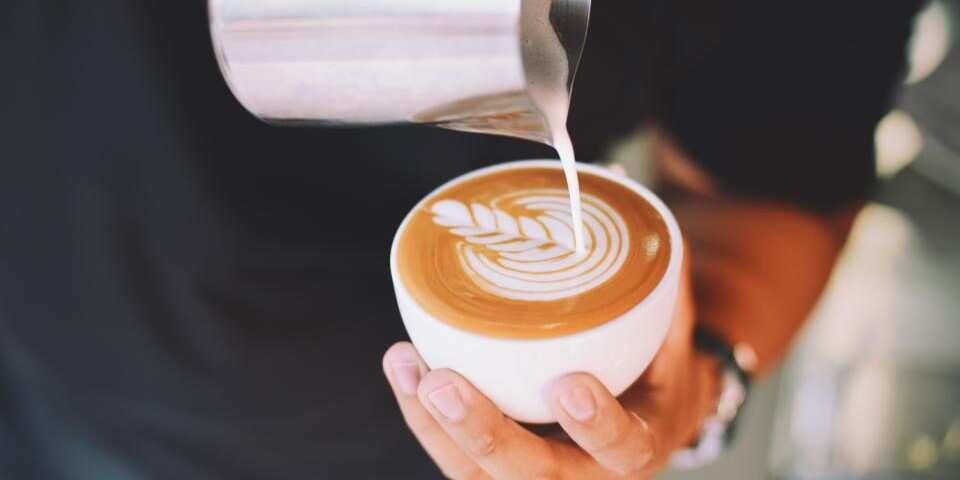 Melk van cappuccino wordt ingeschonken