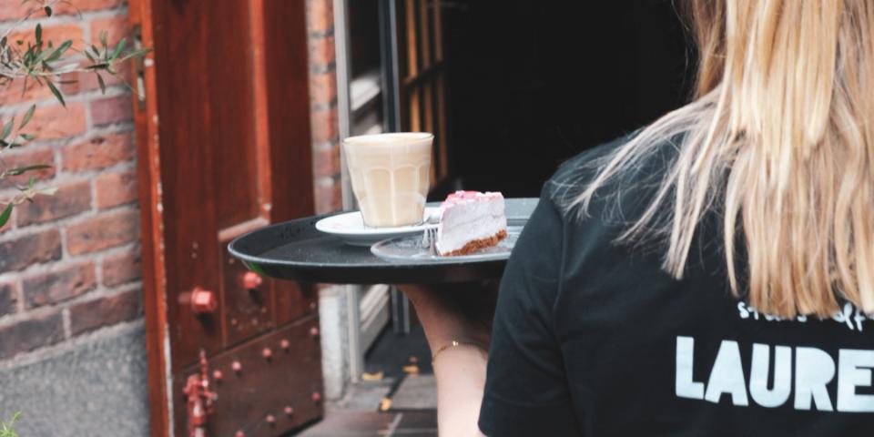 serveerster met koffie in haar handen
