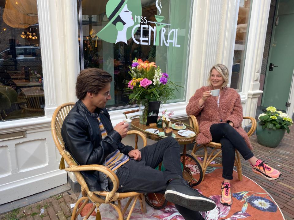 voor het raam bij een tafeltje kopje koffie drinken man en vrouw