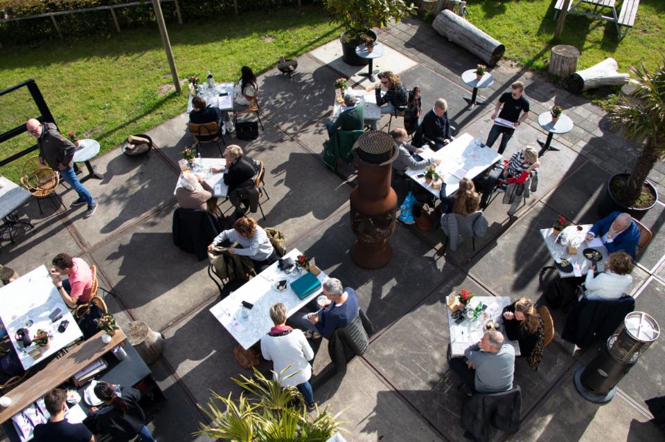 bovenaanzicht van de eendracht met tafels en stoelen in het zonlicht