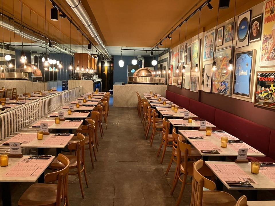 Binnen bij Pizza beppe met tafels met banken en stoelen