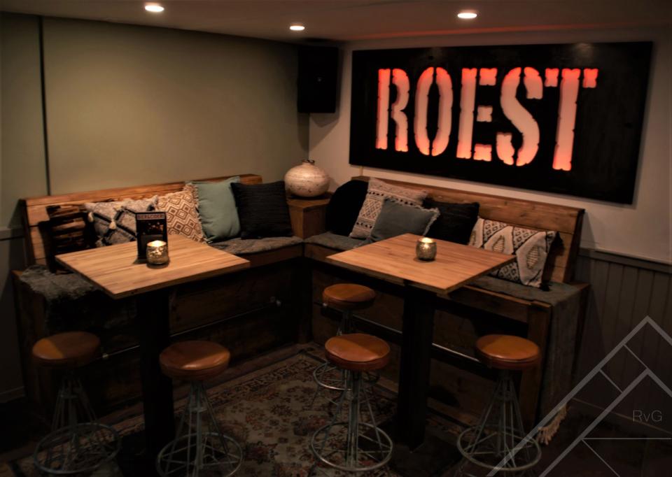 Binnen bij bar Roest met een hoekbank en tafels