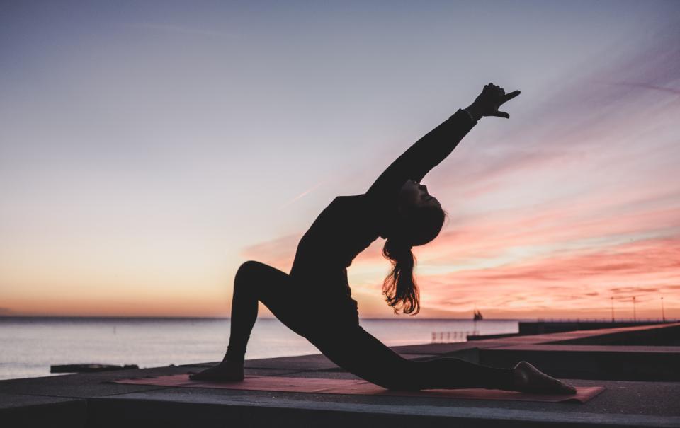 Yoga pose in de buitenlucht tijdens zonsondergang