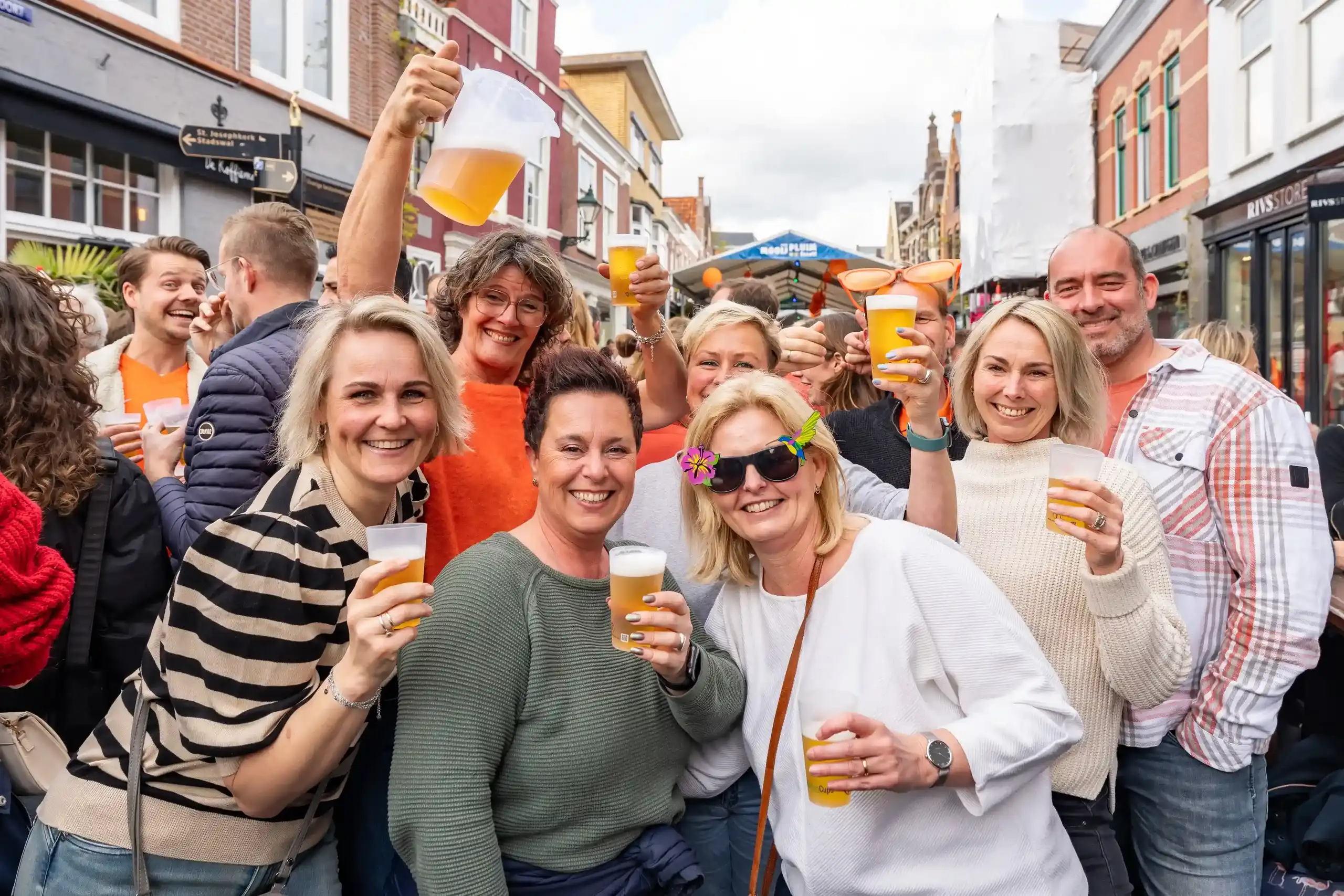 Groep mensen die Koningsdag vieren met herbruikbare bekers in hun hand