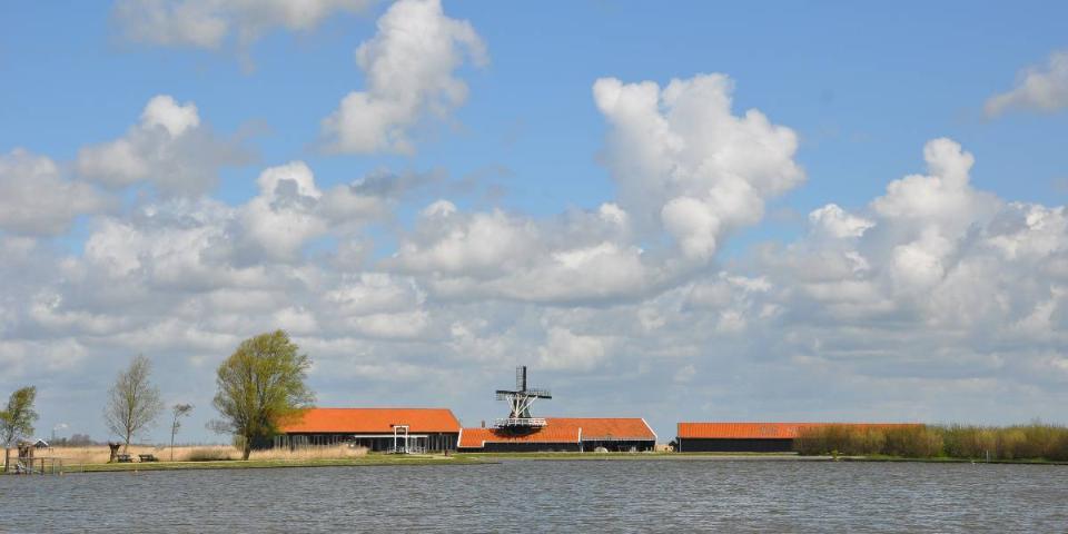 Water met op de achtergrond een huis met molen