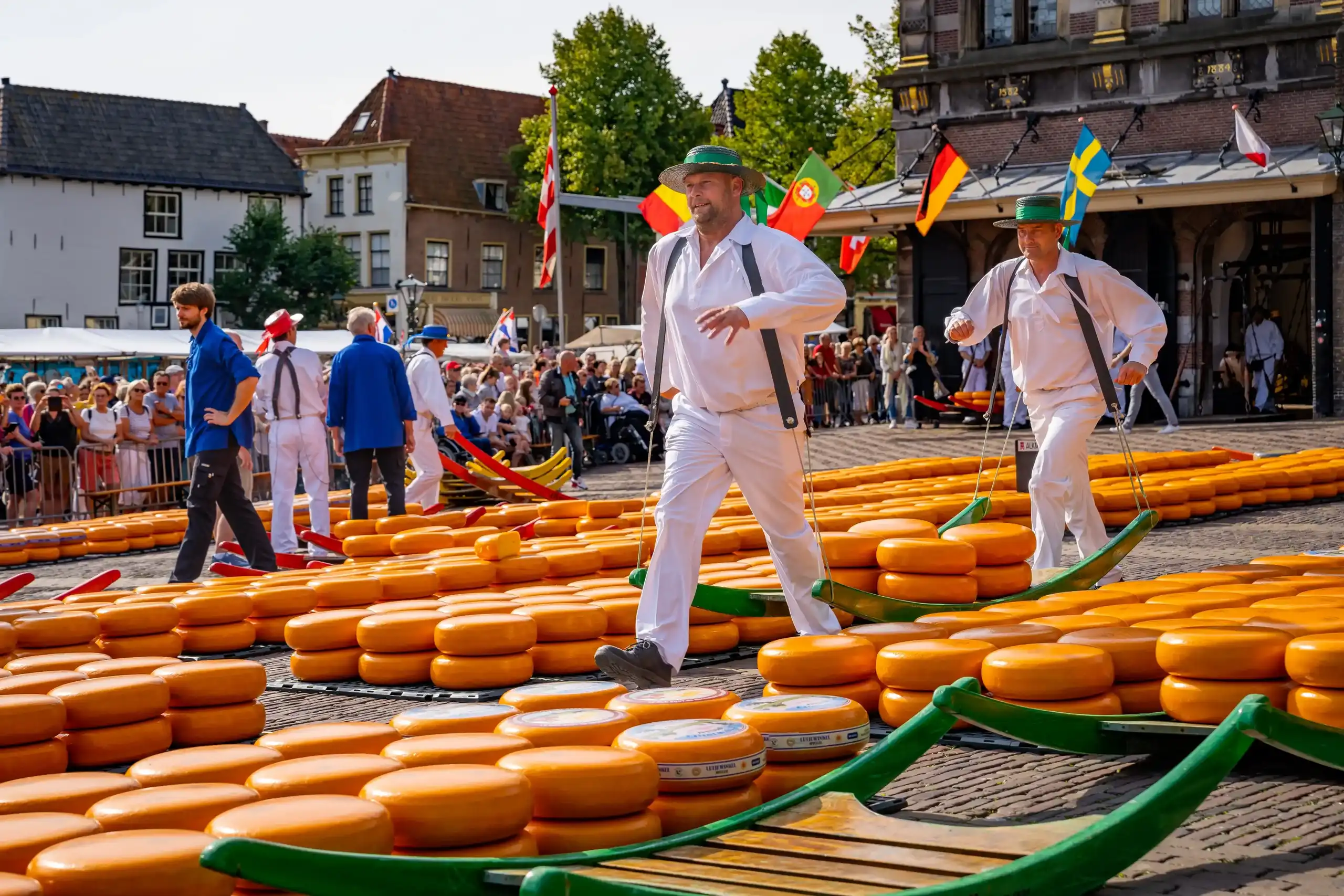 Kaasdragers met berrie lopen door de kazen heen op de kaasmarkt in Alkmaar