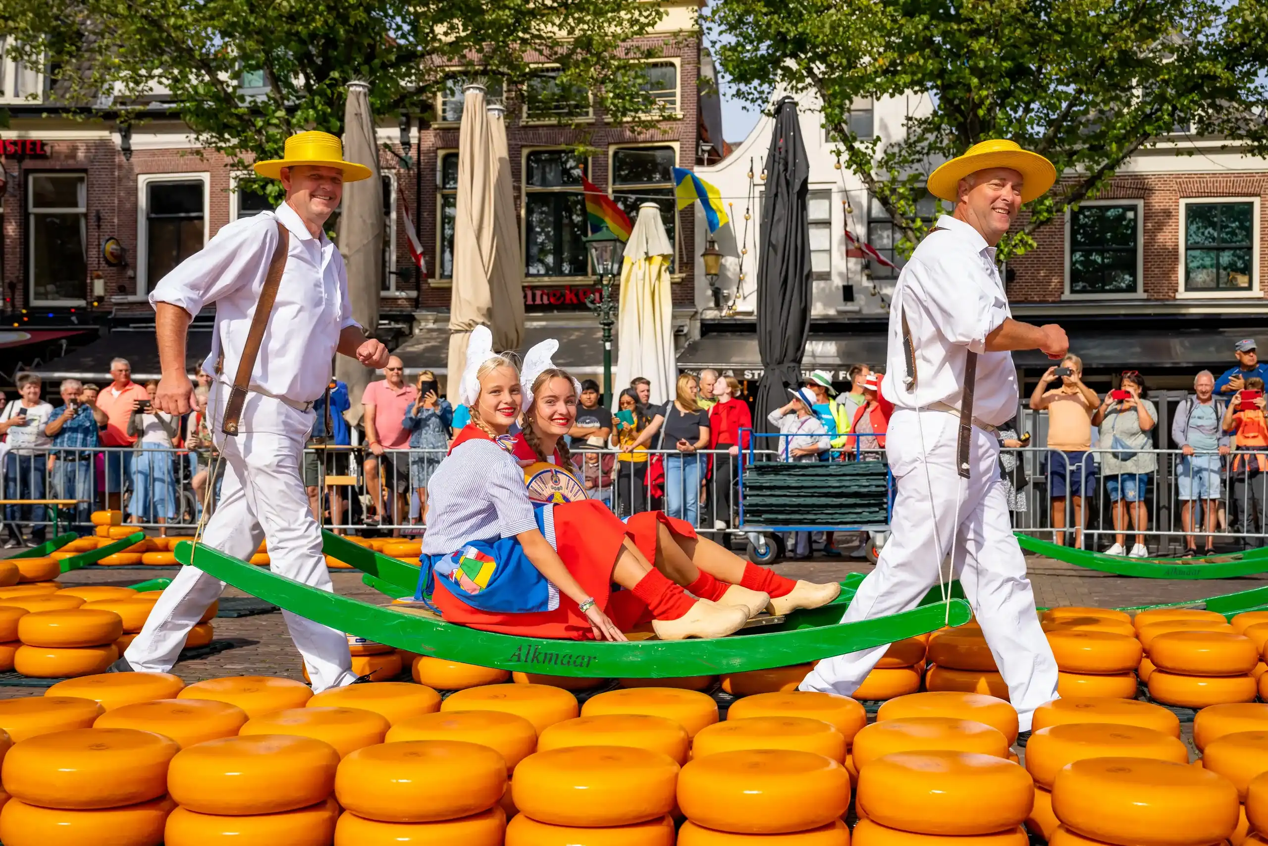 Kaasmeisjes worden op een berrie gedragen door kaasdragers