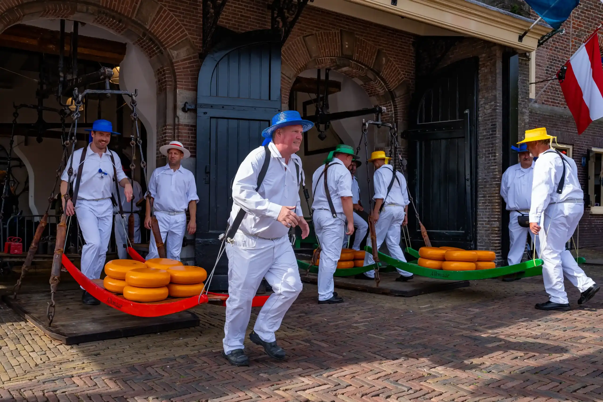 Kaasdragers rennen met een berrie met kaas uit de waagtoren