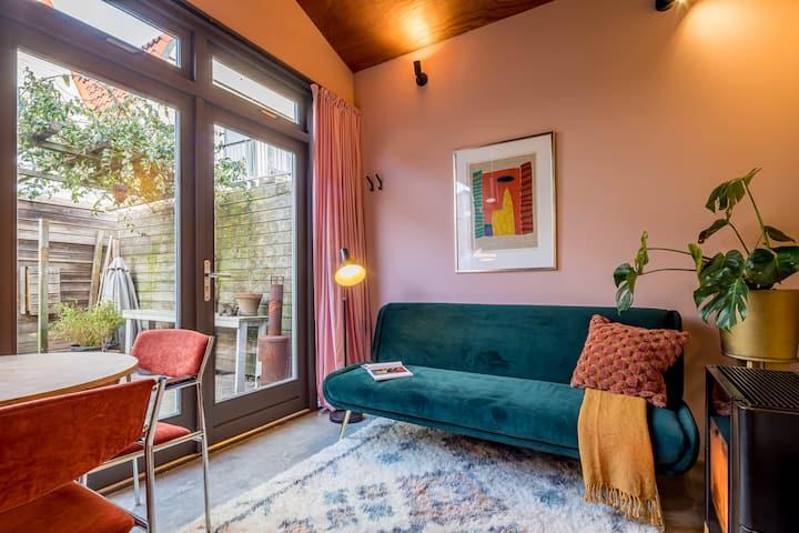 Appartement met een groene bank en een roze muur en sfeerverlichting