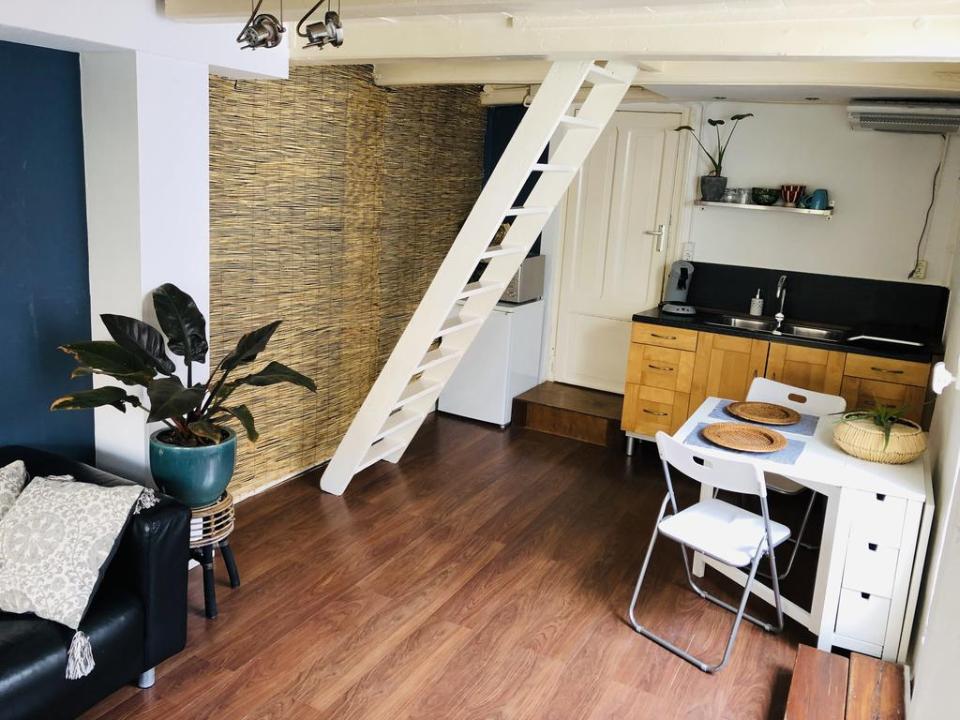 appartement met een wastafel en klein tafeltje met een trap naar boven
