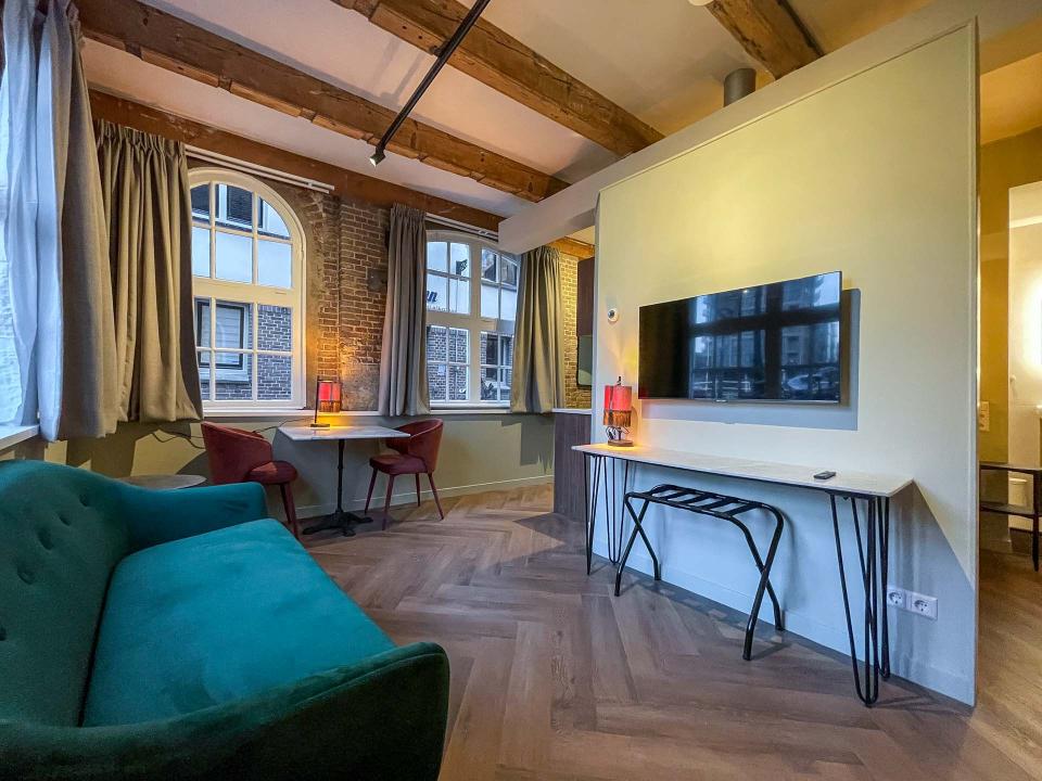 appartement met een groene bank met een tv