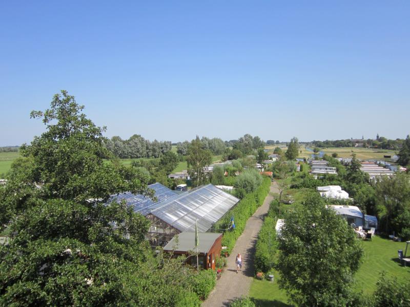 tuinderij welgelegen bovenaanzicht met een pad langs een tuinkas en campers